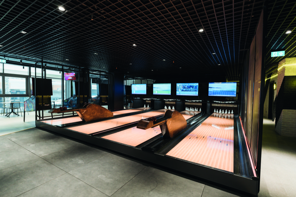 Instalación The Duck — pistas duckpin compactas con pantallas y mobiliario premium